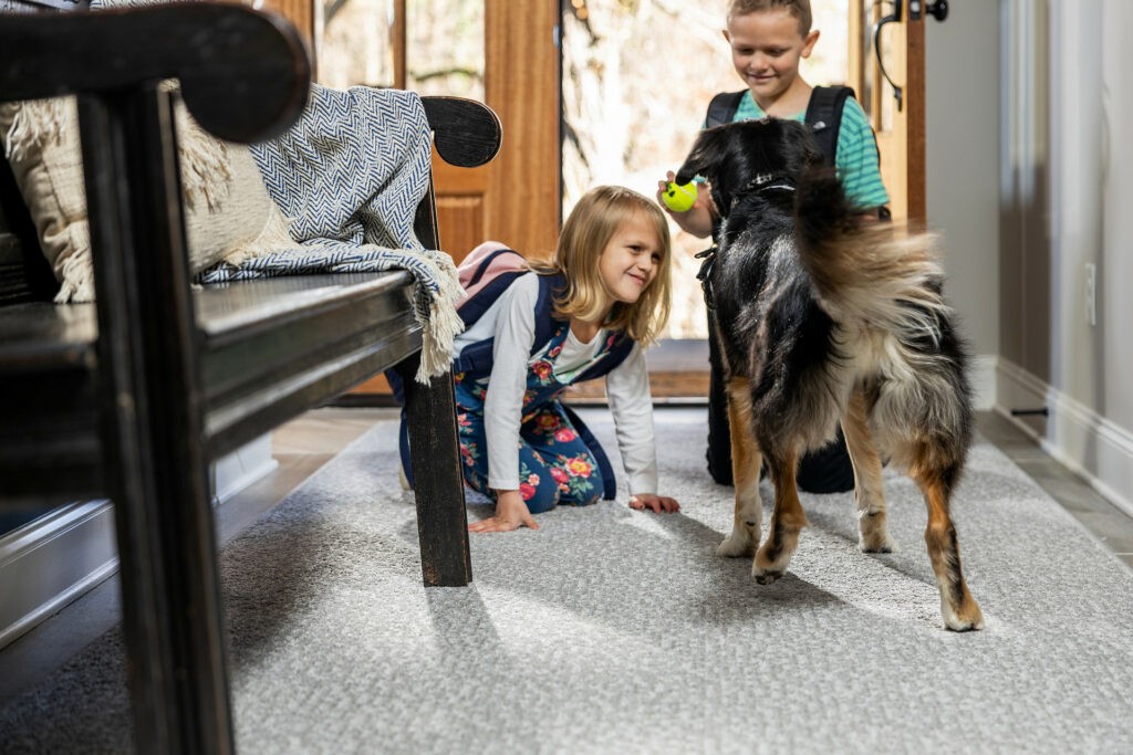 Kids plying with dog on carpet flooring | West River Carpets